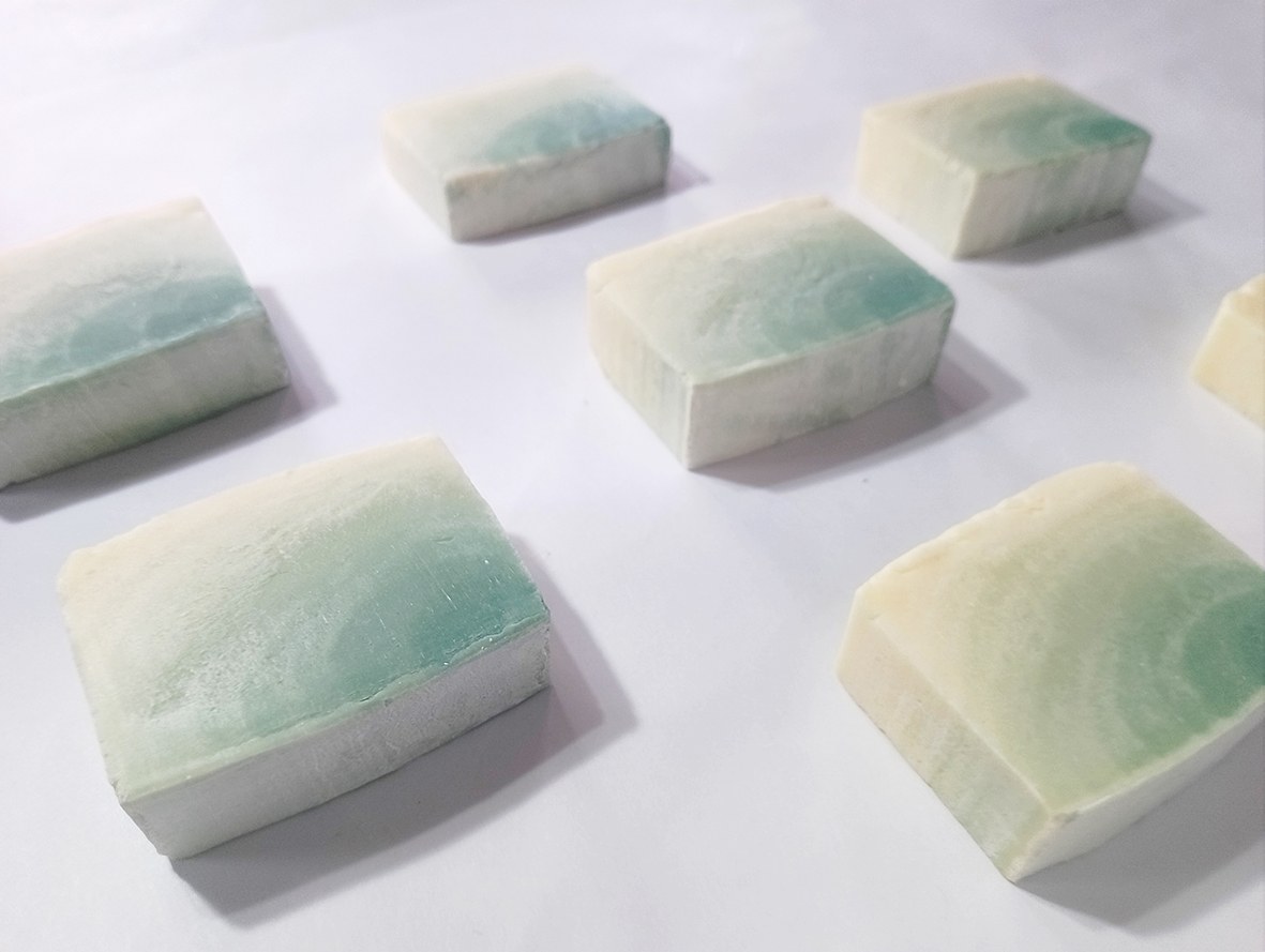 Plusieurs savons ombré vert posés sur un fond blanc.