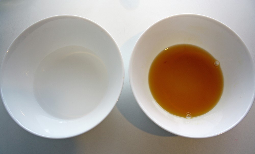 Weighed-out rose water and the oil phase in two white bowls, ready for the water bath.